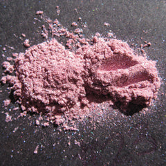 Loose pigment eyeshadow, pink lavender powder with shimmer on dark surface