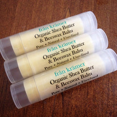 Lip balm tubes with white and clear plastic, from krämer text, and light yellow balm inside