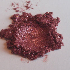 Eye shadow, burgundy mineral powder with glitter, close-up view on white surface