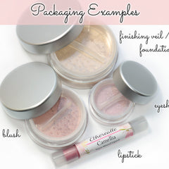 Close-up of peach tan eyeshadow with blue shimmer being applied to eyelid with brush