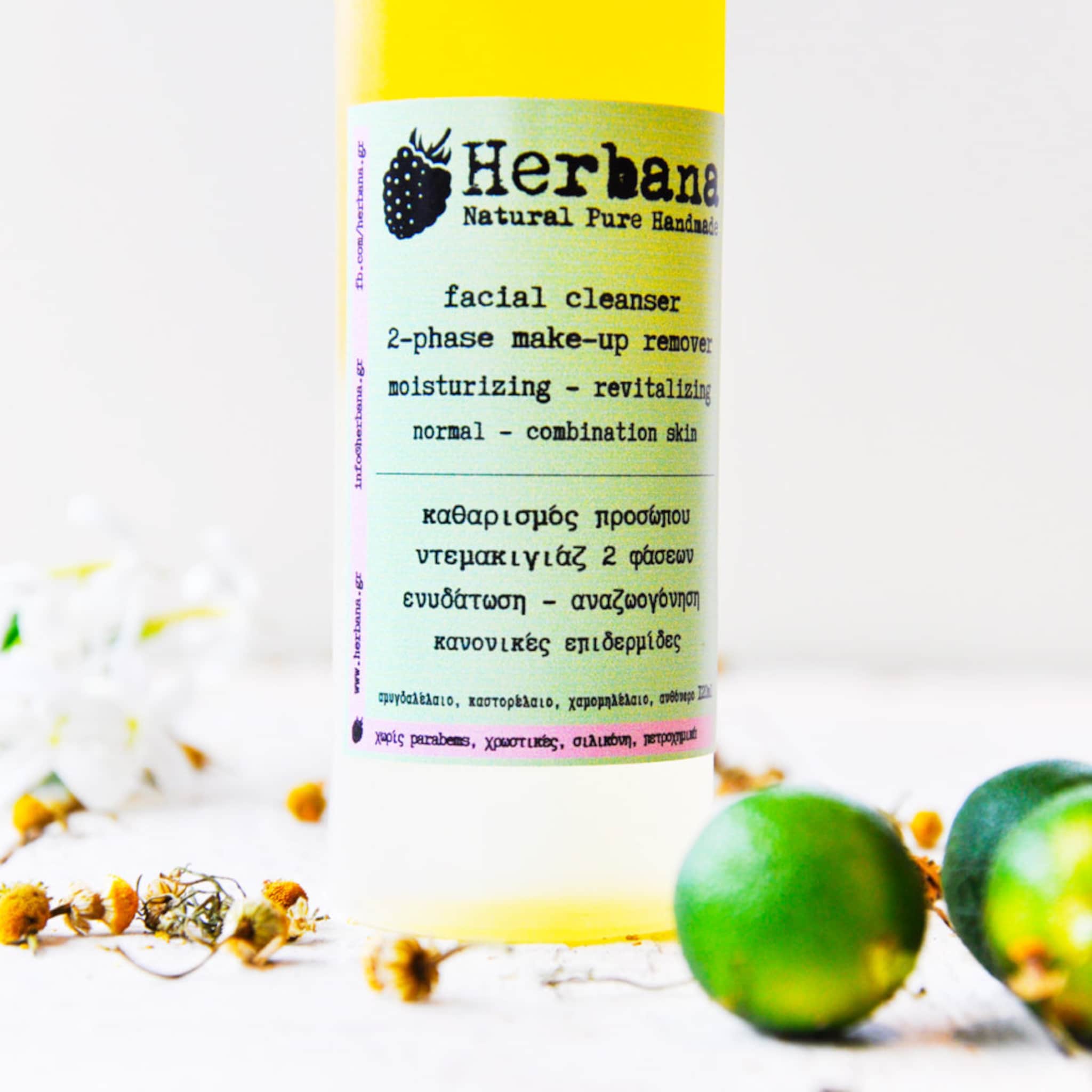 Facial cleanser bottle with yellow liquid, green and white label, Herbana brand name visible
