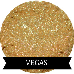 Close-up of sparkling gold eye shadow in a round compact with reflective surface and shimmer particles
