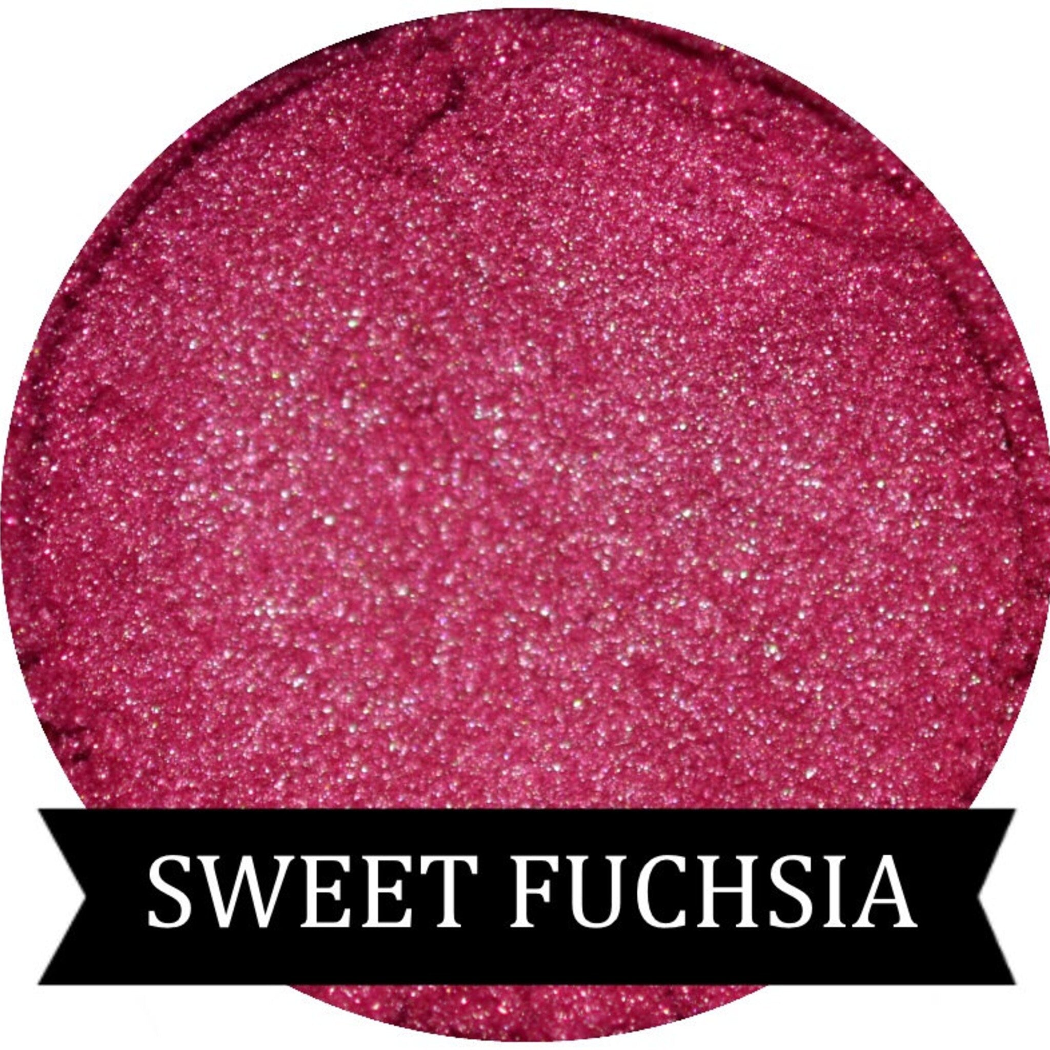 Close-up of Sweet Fuchsia mineral eyeshadow in compact with shimmering pink pigment and satin finish