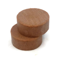 Facial cleanser soap, brown round bars, stacked on white background