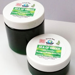 Face scrub jars with white lids, green labels, and dark green jars, "Sea of Green" branding visible