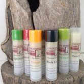 Lip balms with colorful caps, Chickenmash Farm brand, on wood display