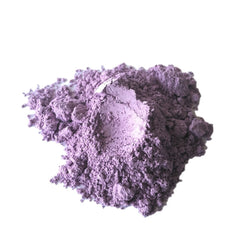 Eye shadow powder in matte purple, lilac, and mauve colors, close-up view against white background