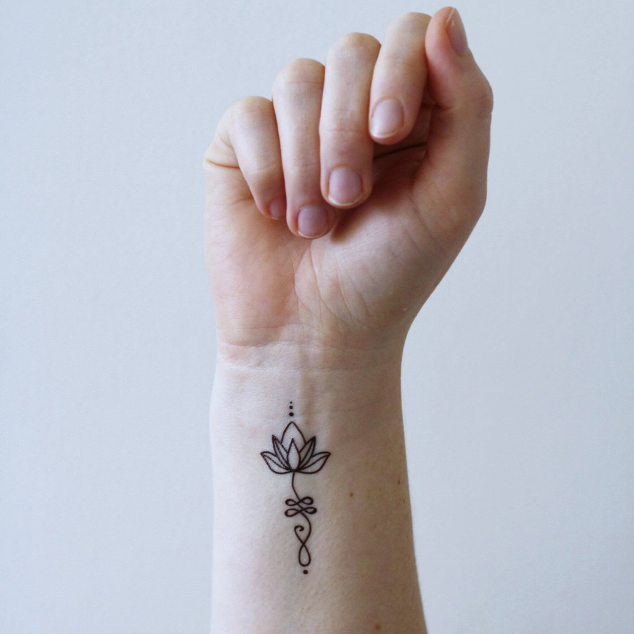 Close-up of boho lotus temporary tattoo set with intricate unalome designs on skin-safe transfer paper