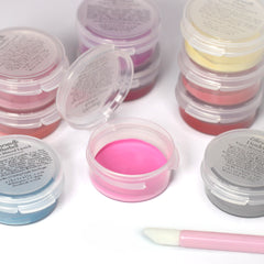 Mineral lipsticks in various colors, in clear plastic containers, with a pink applicator wand