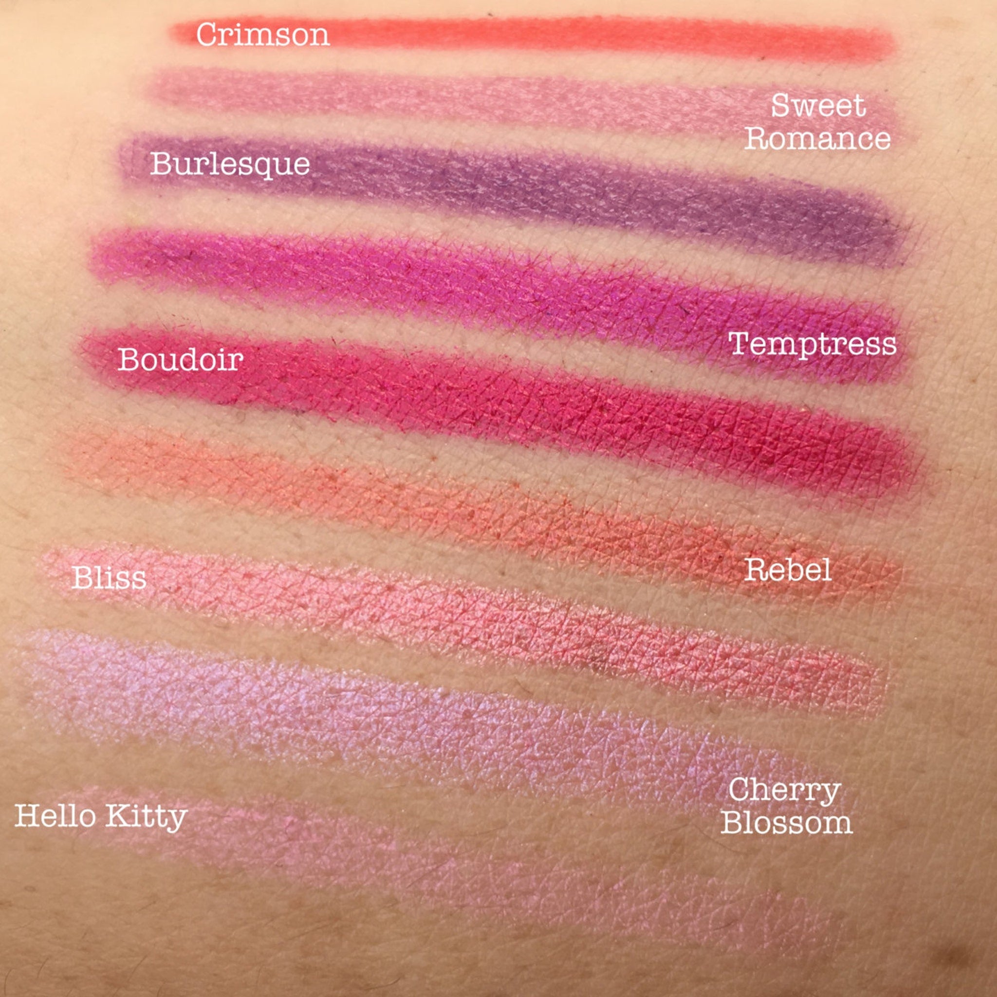 Lipstick swatches in various colors, including crimson, pink, and purple, on skin