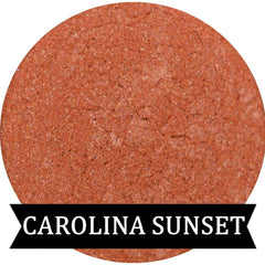 Close-up of Coral Sunset eyeshadow pan with vibrant pink shimmer and warm orange undertones