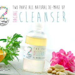 Facial cleanser bottle with yellow liquid, white label, and floral design, surrounded by flowers and nuts