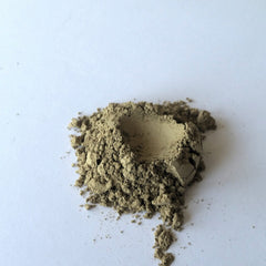 Powdered substance, tan color, granular texture, on white surface