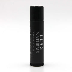 Lip balm tube in black with white text, LEVS NATURALS brand visible, cylindrical shape