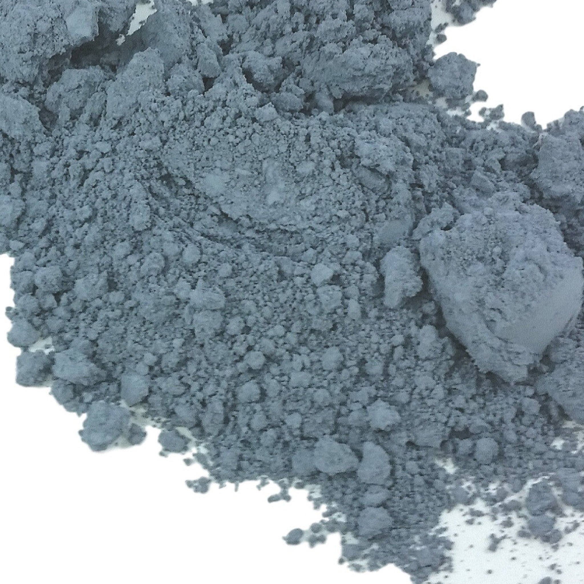 Woman applying soft periwinkle blue eye shadow with fingertip, blending along eyelid crease
