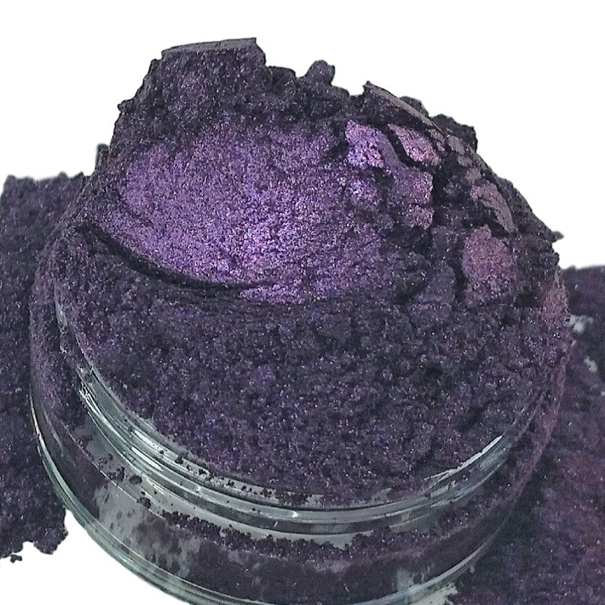 Purple powder in glass jar, with textured and sparkly appearance, on white background
