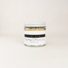 Exfoliant jar with white lid, clear glass, and white label with "Damn Good Exfoliant" text