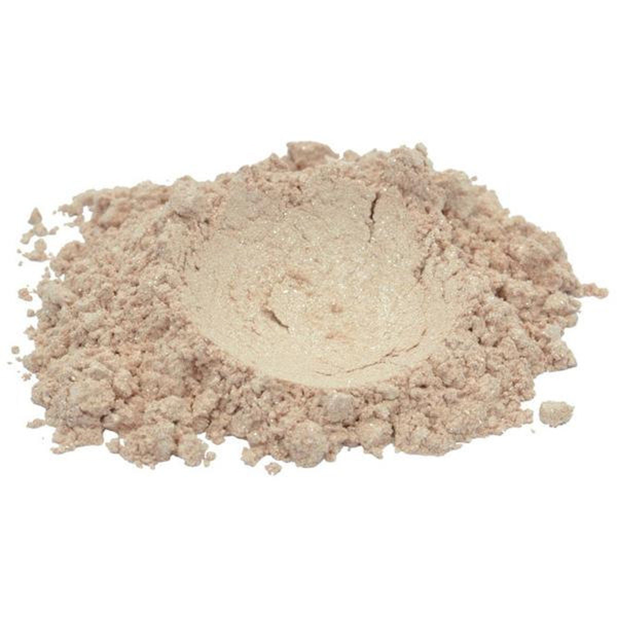 Hand applying shimmering ivory beige mica eyeshadow powder with a fluffy brush onto eyelid.