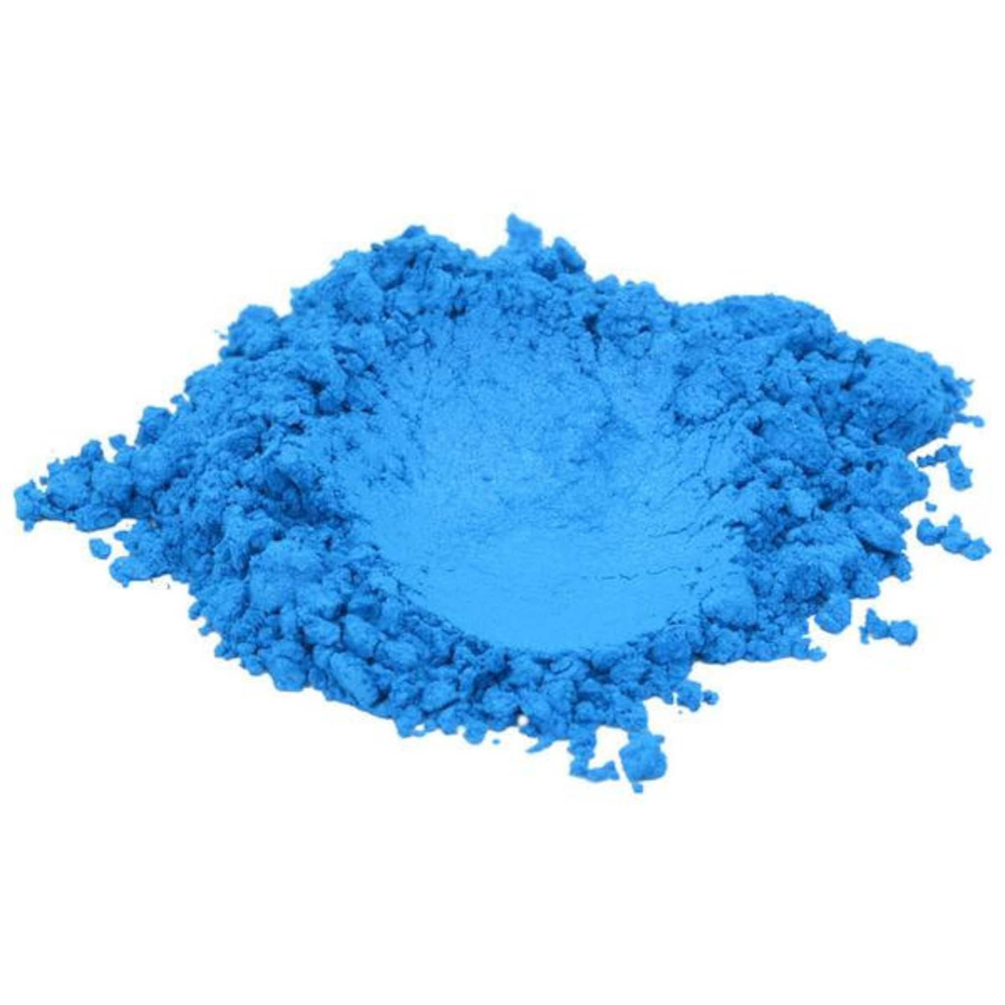True Blue mica pigment powder spilled on marble surface showing vibrant shimmer and fine texture