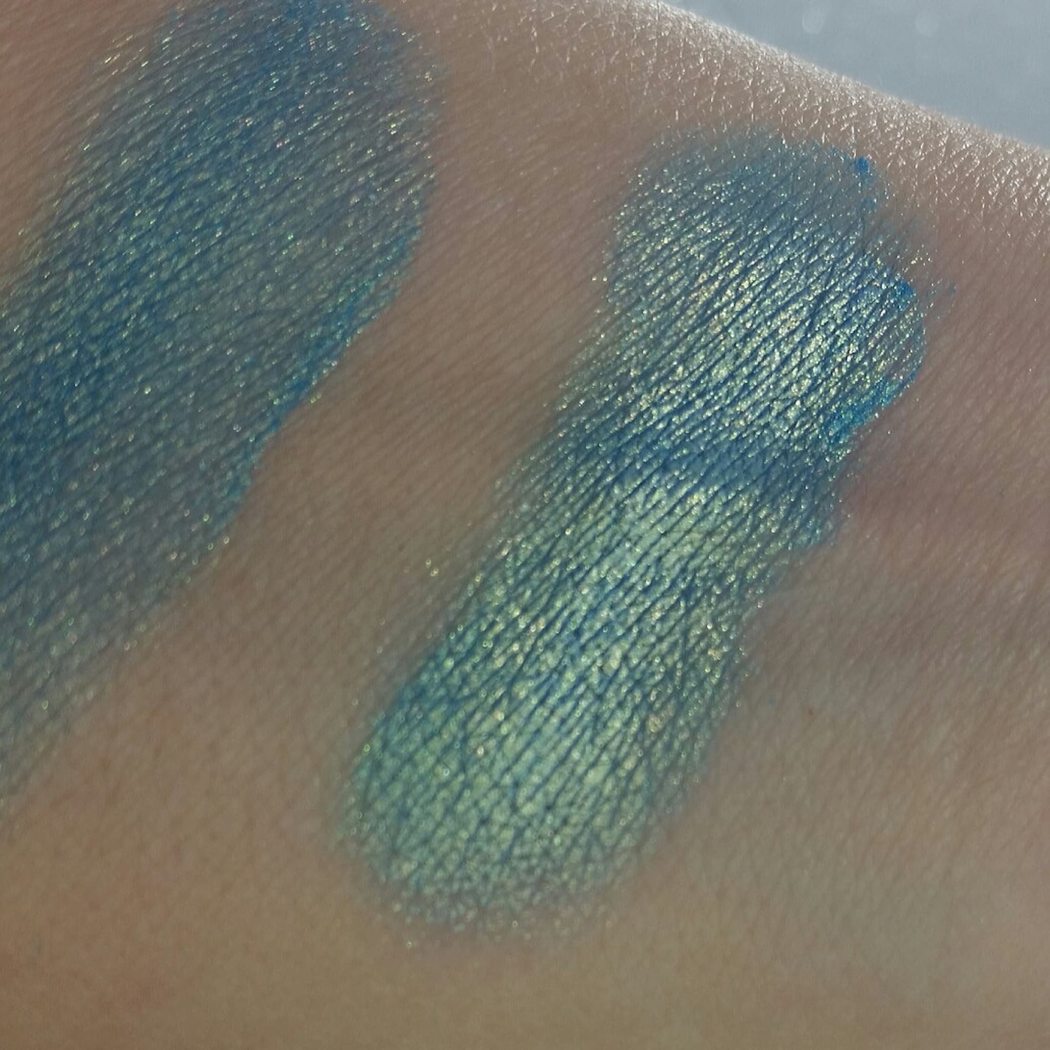 Eyeshadow swatch, blue green shimmer, textured application on skin