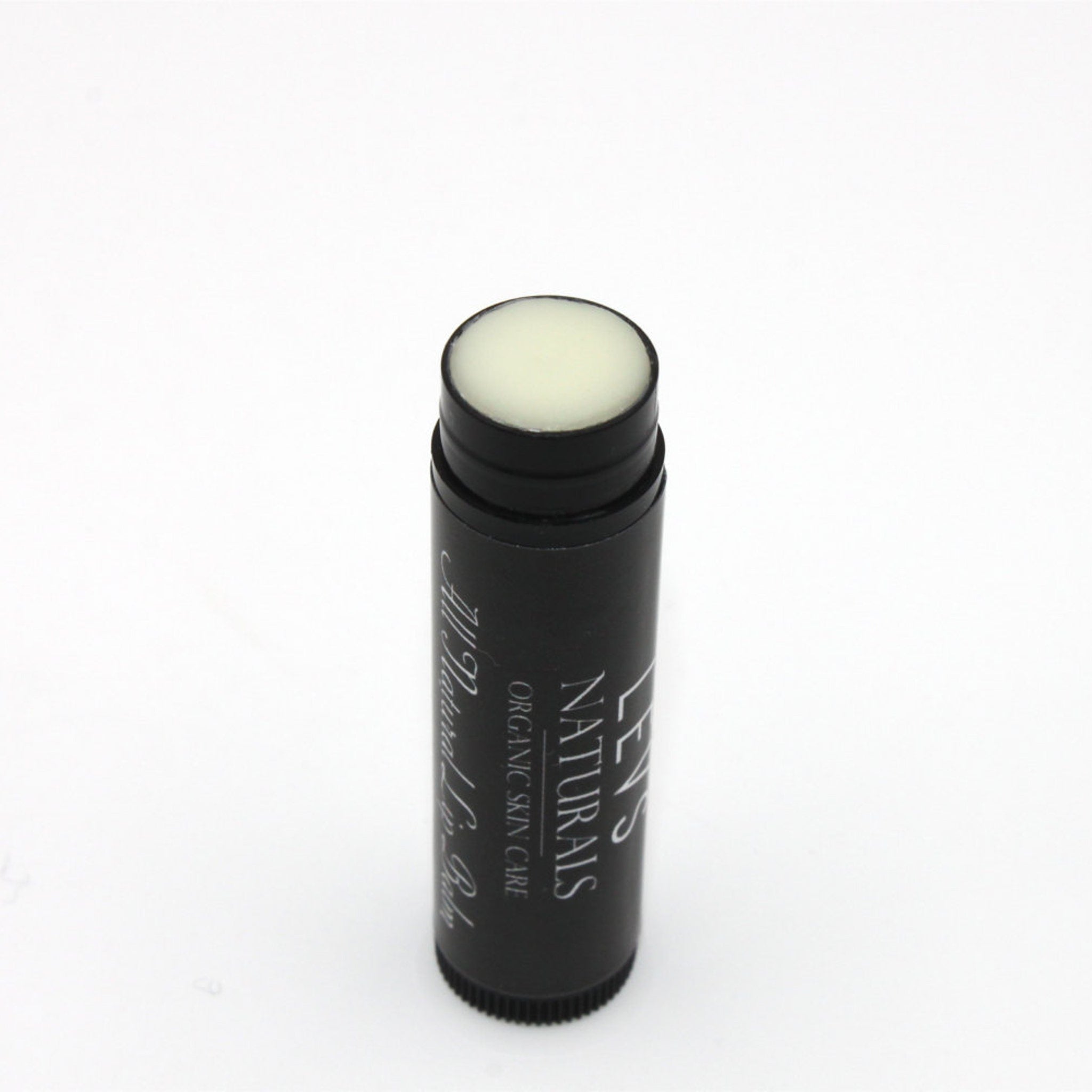 Lip balm stick with black tube, white balm, and "LEVS NATURALS" text visible