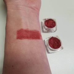 Side view of burgundy shimmer eye shadow powder in sifter jar with berry kiss label