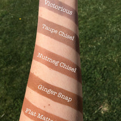 Makeup swatches in various brown shades on arm, with text labels in white font