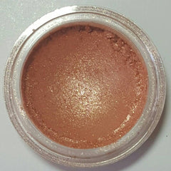 Side view of gold blush eyeshadow compact showing shimmer texture and embossed pan design