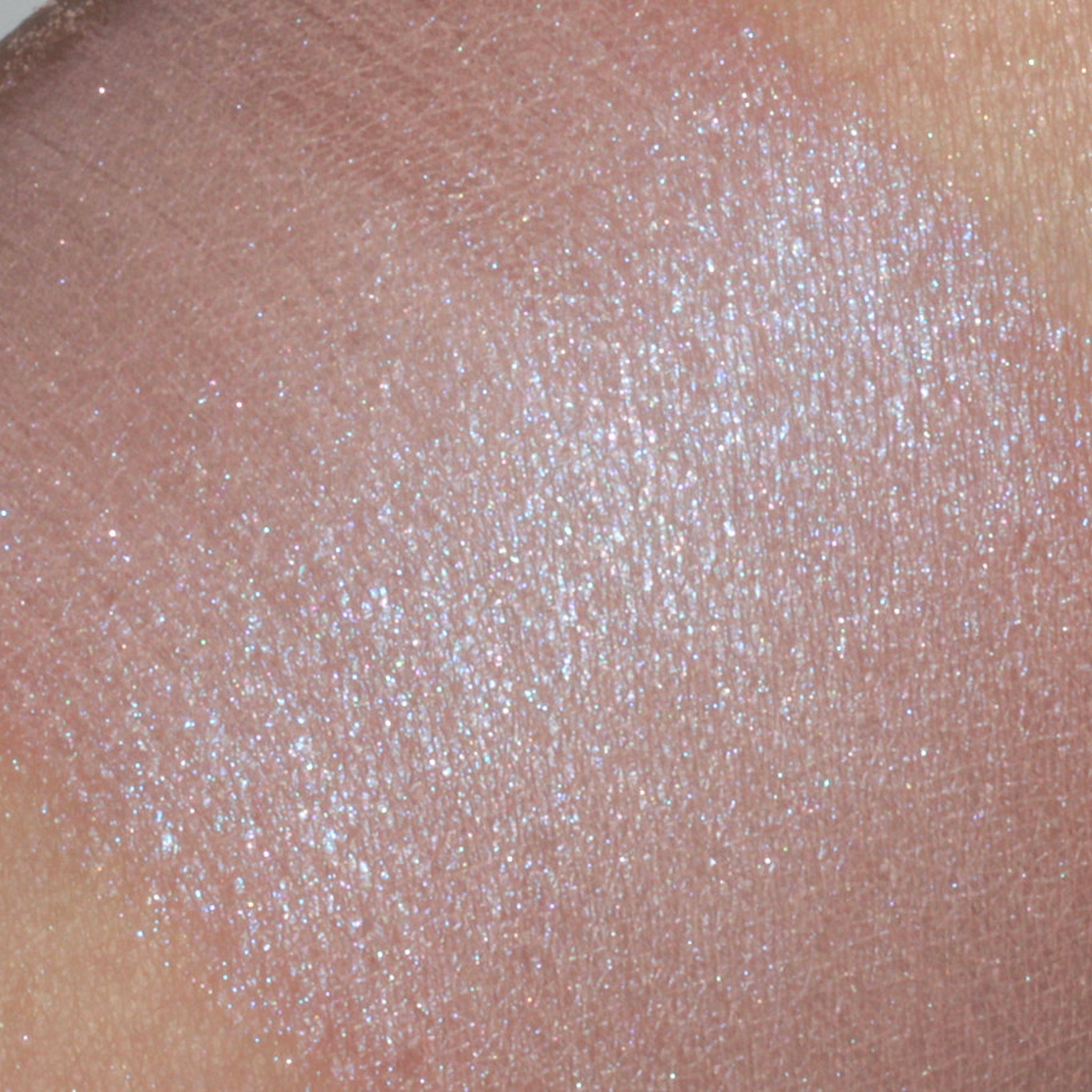 Close-up of peach tan eyeshadow with vibrant blue shimmer particles, showcasing vegan mineral makeup texture