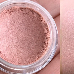 Close-up of hand applying matte brown eyeshadow with a fluffy brush onto eyelid