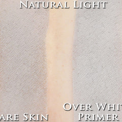 Hand applying matte light neutral grey vegan loose powder eyeshadow with a brush