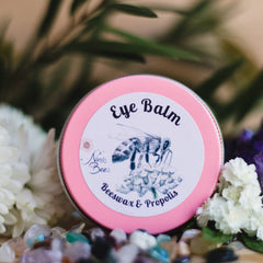 Eye balm in pink tin with white label and bee illustration, Nin's Bees brand name visible