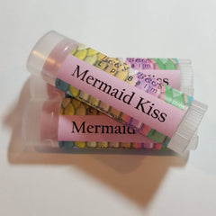 Lip balm tubes with pink labels and mermaid scale pattern, "Mermaid Kiss" text
