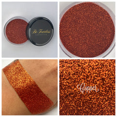 Close-up of copper loose glitter eyeshadow in a small sifter jar with metallic sheen and fine sparkle particles