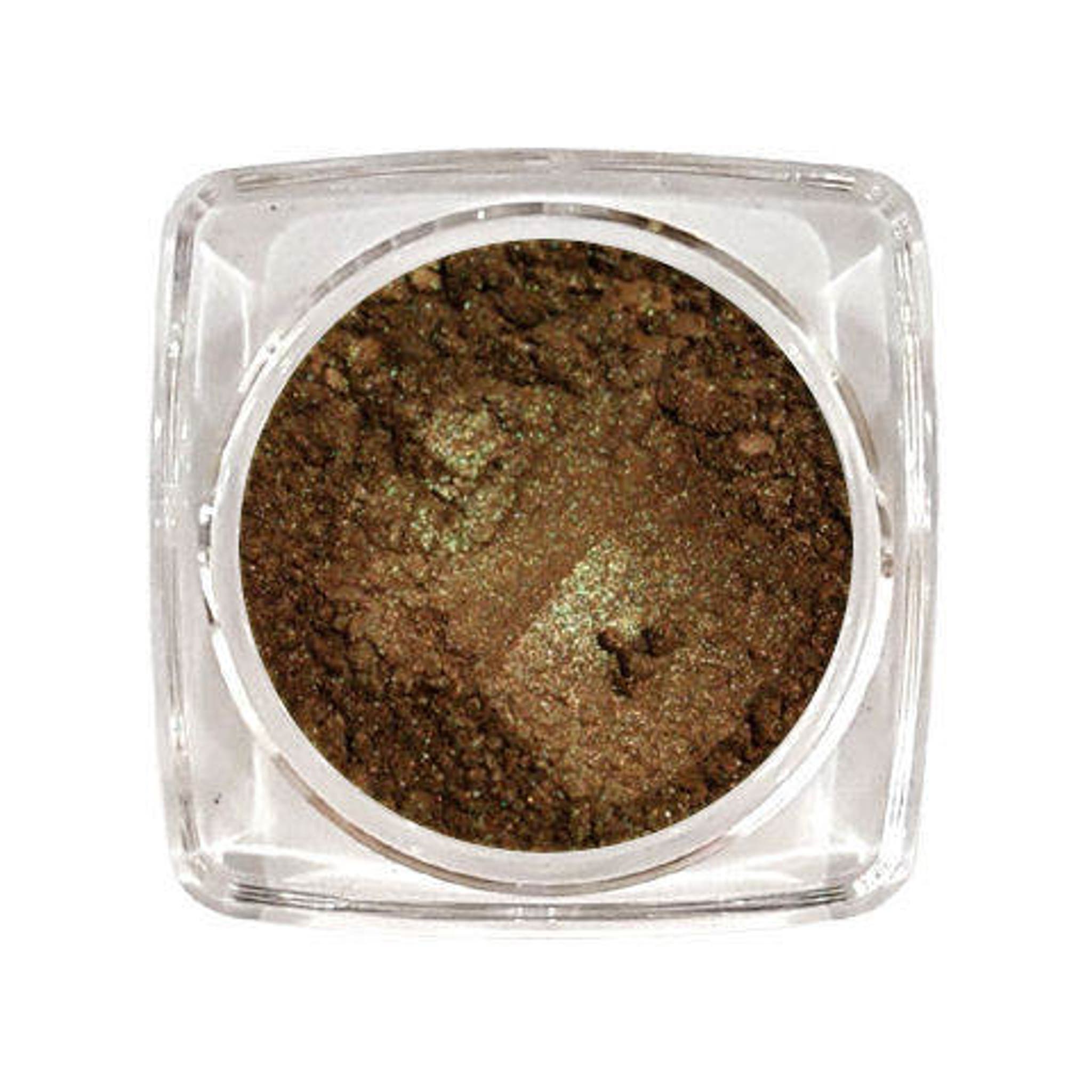 Small glass jar of autumn green pressed eyeshadow with gold lid on white background