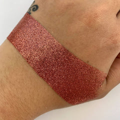 Close-up of sparkling rose gold loose glitter particles shimmering in natural light