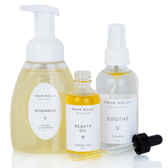 Skincare set with white bottles, clear glass, and yellow liquid, "From Molly With Love" brand