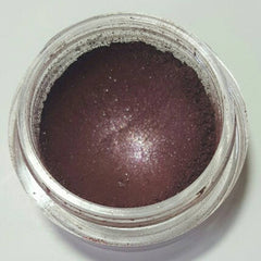 Side view of Escapade Eye Shadow compact showcasing its sleek black case and shimmering bronze powder texture