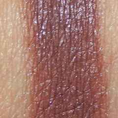 Close-up of Escapade Eye Shadow pan showing shimmering bronze pigment with smooth, blendable texture