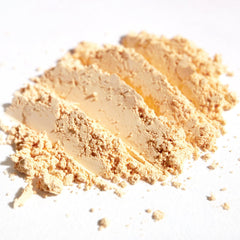 Close-up of matte pastel peach loose pigment eyeshadow with soft apricot ivory undertones in jar