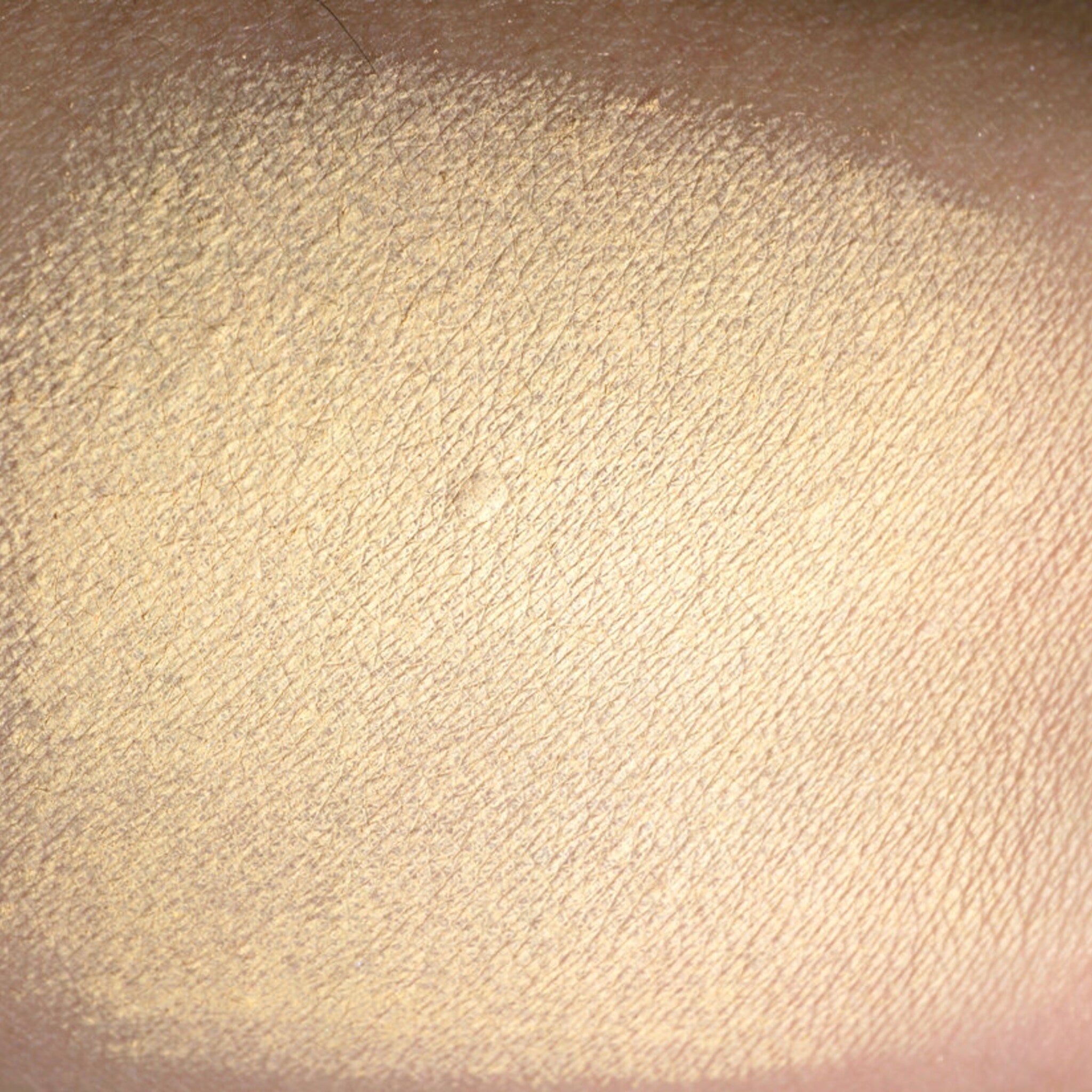 Side view of matte pastel peach loose pigment eyeshadow in a sifter jar with apricot undertones