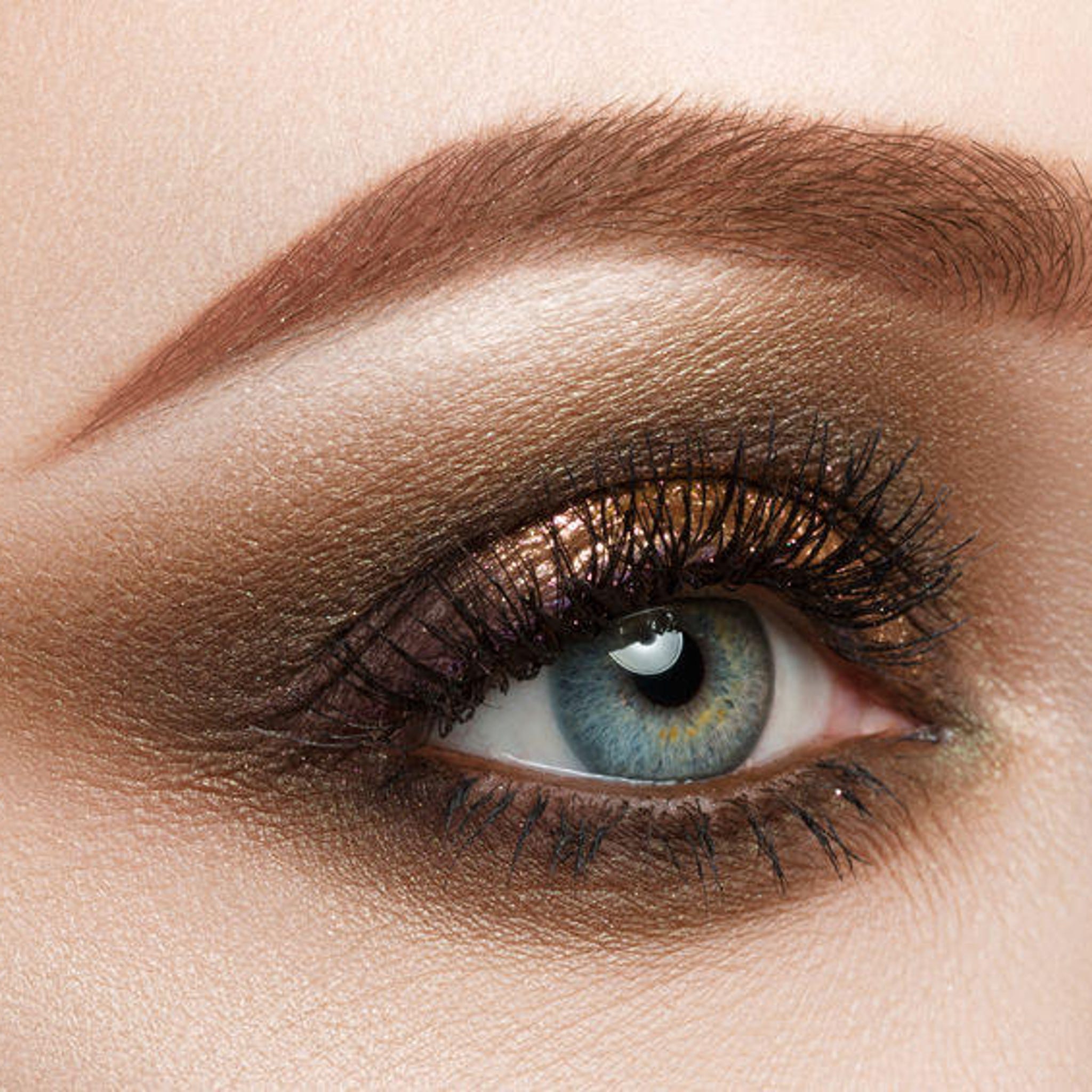 Side view of loose mineral eyeshadow in shimmering fire rose shade with natural pigments, showcasing texture
