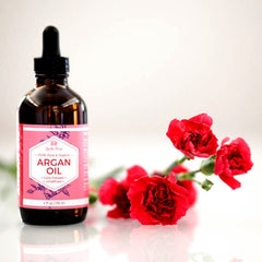 Amber glass bottle of pure cold-pressed argan oil with gold dropper and minimalist label