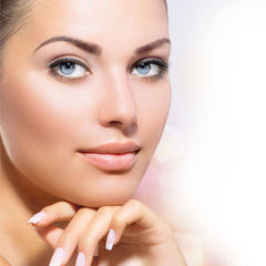 Woman's face with light skin, blue eyes, and long eyelashes, resting hand on chin