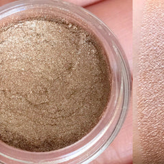 Compact of vegan mineral eyeshadow in shimmering neutral tones with sleek black packaging