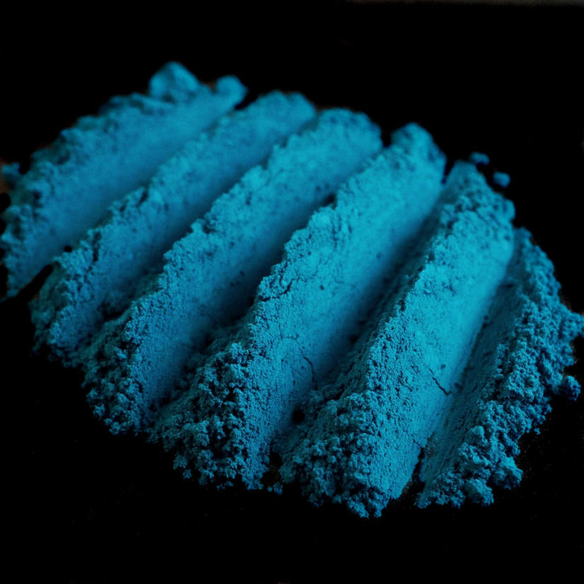 Dark peacock teal loose eyeshadow in matte finish from vegan mermaid collection, shown in open jar.