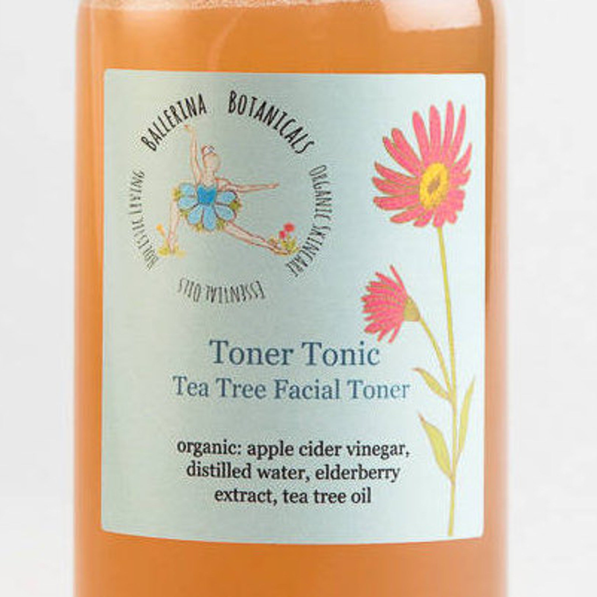 Facial Toner bottle with orange liquid, light blue label, and pink flower illustration