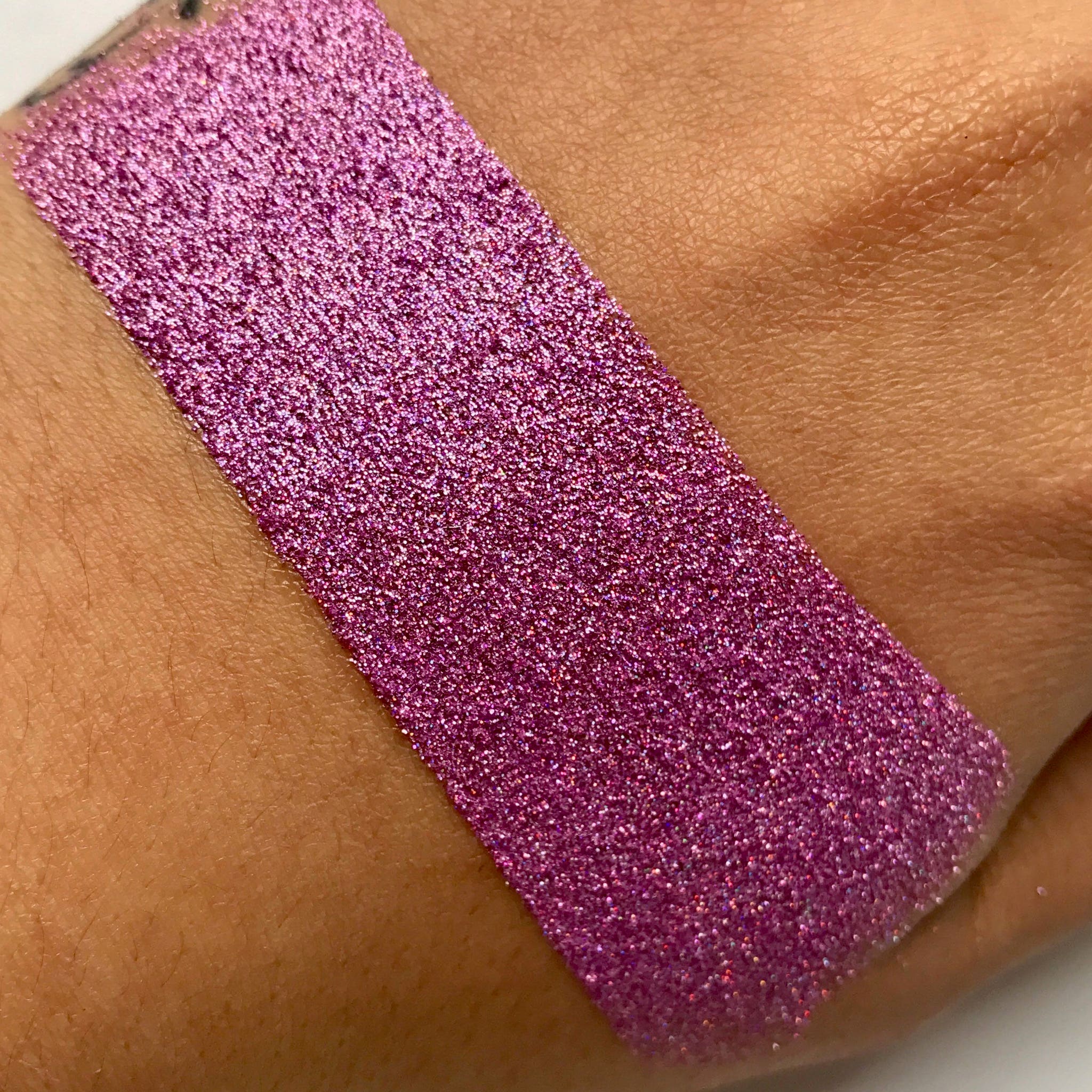 Close-up of sparkling pink Fairy Dust loose glitter with ultra-fine shimmer particles in a clear jar