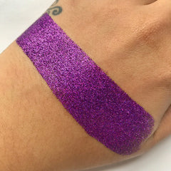 Close-up of loose glitter eye shadow in a shimmering champagne hue with fine sparkle particles