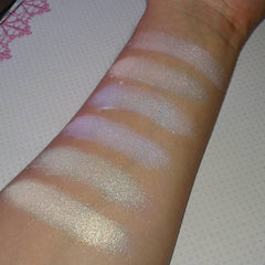Swatch samples of shimmering white and iridescent makeup on arm, showing color and texture